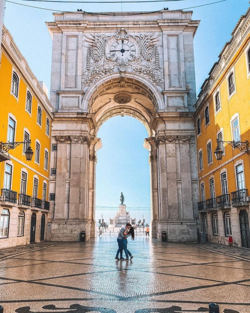 couple in front of grand archway Lisbon Portugal