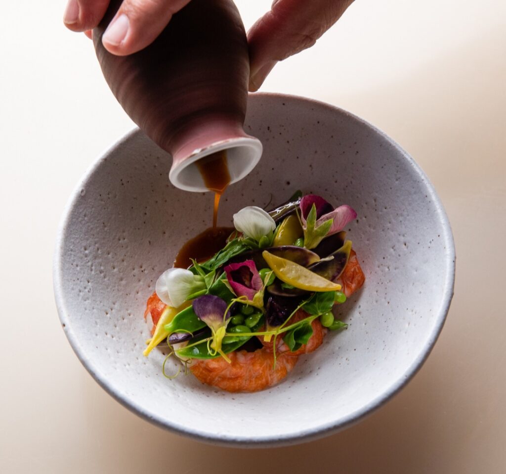 A colourful dish of Redclaw yabbies, heirloom peas, white squash, fermented chilli yuzu and ume broth, as served at Bennelong Restaurant inside the Sydney Opera House.