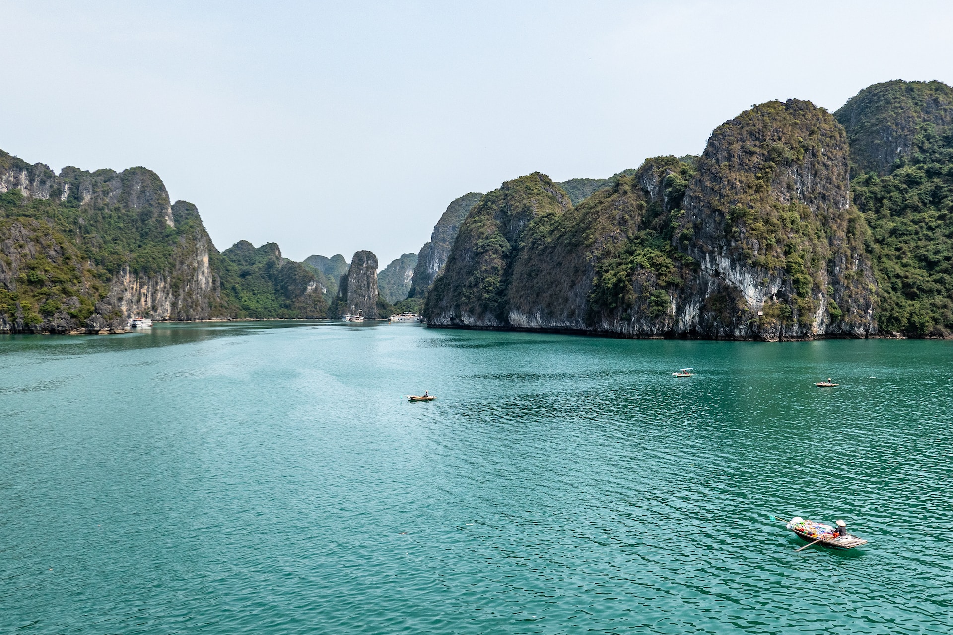 Aerial image of Ha Long Bay, with two fishing boats in the foreground, and the towering limestone formations rising up in the near distance