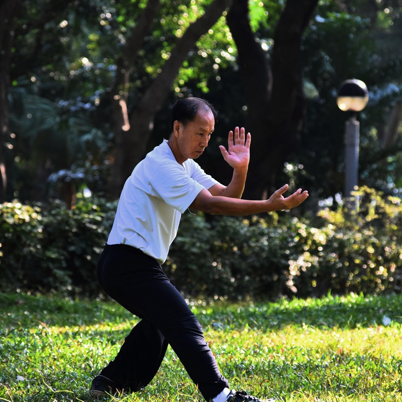 man practising tai chi in a park