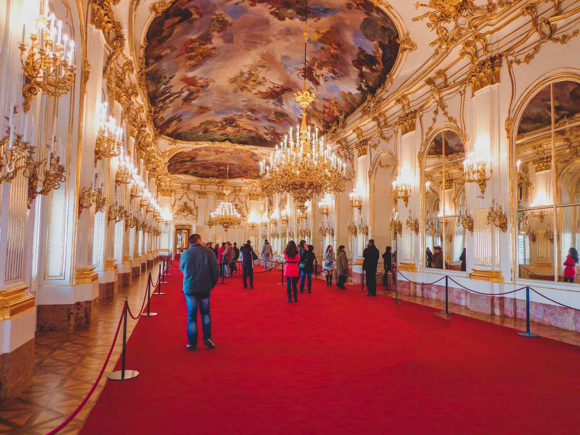 Interior of grand room at schonbrunn palace with visitors, Vienna 