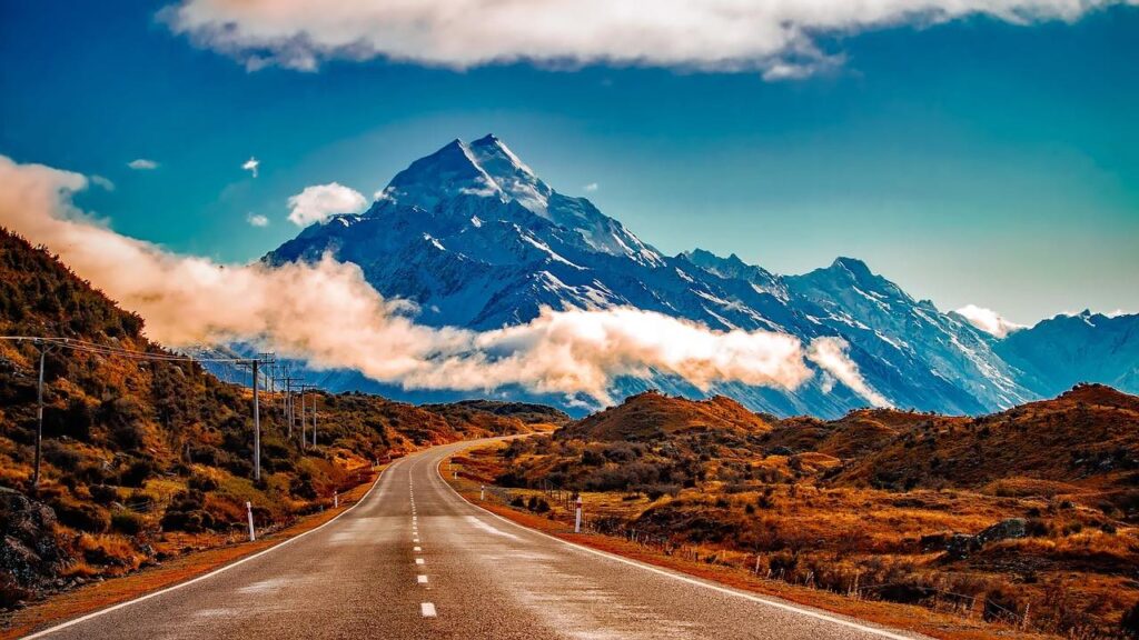 Road with mountainous landscape in background with low level clouds, newzealand