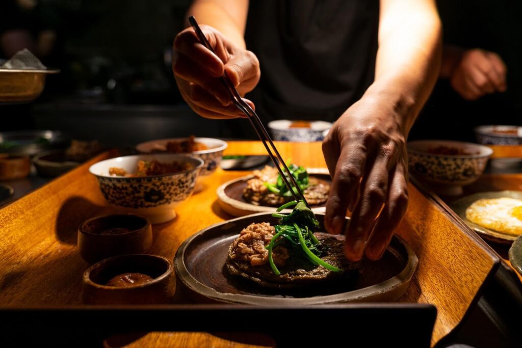 Chef placing vegetables dish at toyo eatery, Philippines 