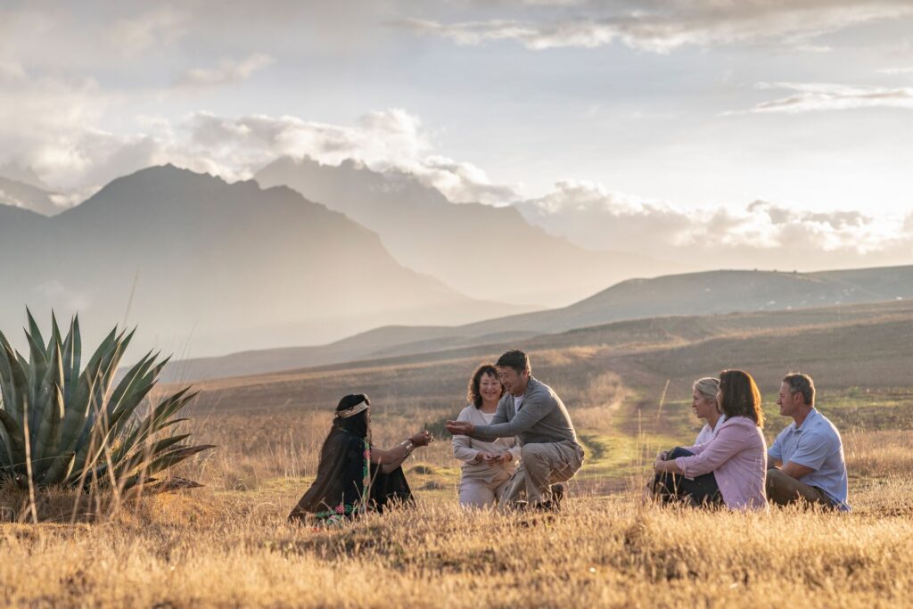 Luxury Gold guests meet a Shamen in Peru’s Sacred Valley, on fertile grasslands with mountains in the background.