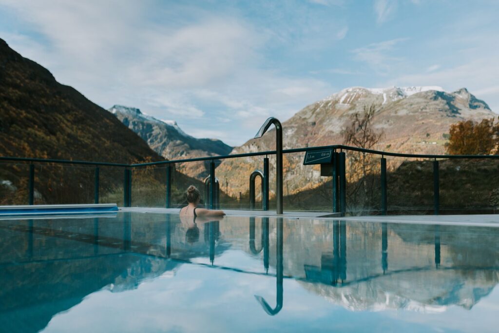 A woman relaxes in the outdoor pool of the Union Hotel overlooking Geiranger Fjord in Norway