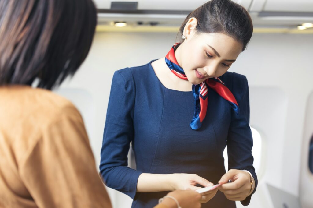 Flight attendant checking a passenger's ticket