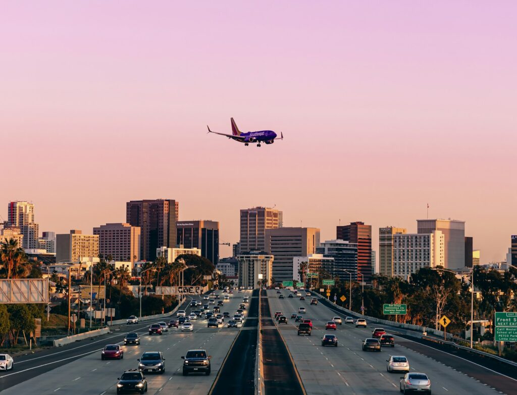 Plane coming into land over a busy freeway