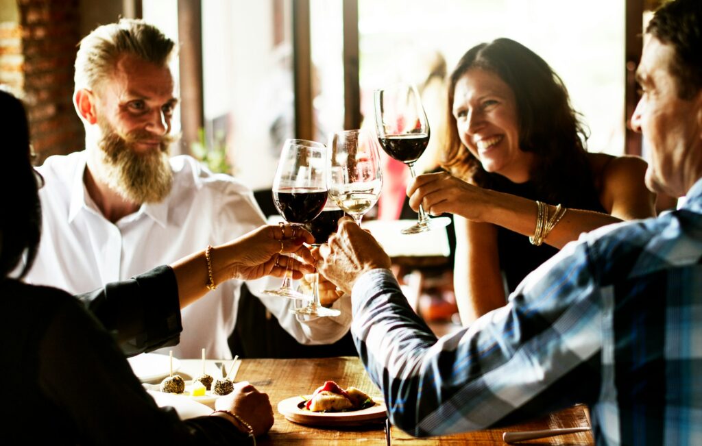 Restaurant diners clinking wine glasses together over food