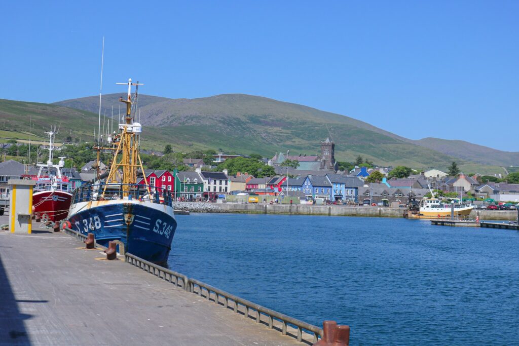 Fishing boats in a harbor with colorful buildings in the background