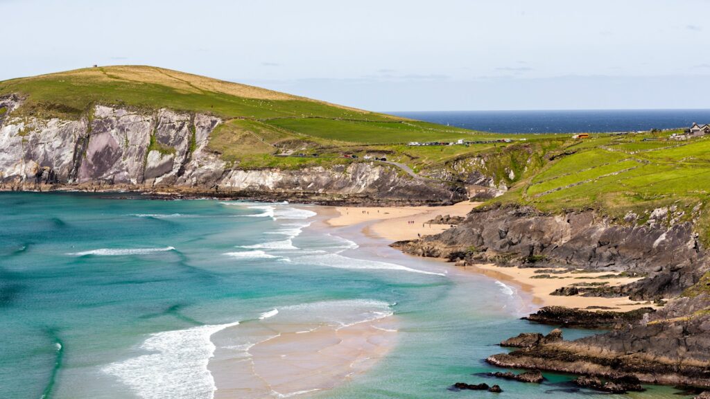 Aerial view of a stretch of coastline with blue water and sandy beach