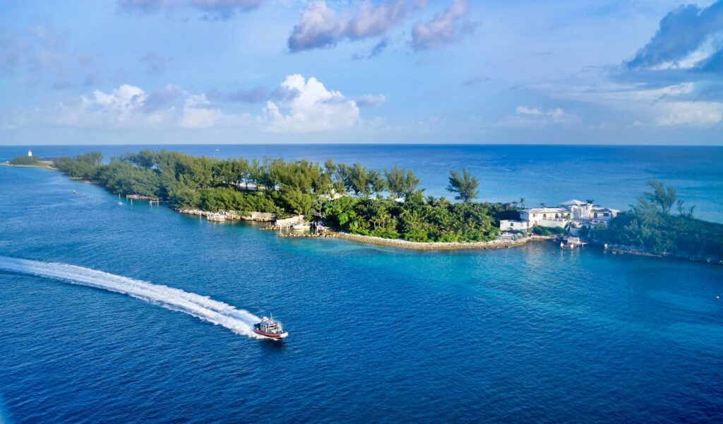 Speed boat driving on blue water past an idyllic looking island